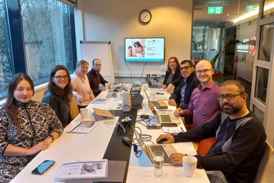 Project partners sitting on both sides of a table at the co-designing workshop in Tallinn, November 2024.